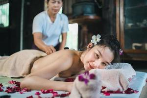 massage- en spa-ontspannende behandeling van het kantoorsyndroom met behulp van traditionele Thaise massagestijl met hete stenen. zoals een vrouwelijke masseuse die massage doet, behandelt rugpijn, armpijn, stress voor vrouw die moe is van het werk. foto