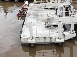 de longtailboot drijft dichtbij het concrete ponton. foto