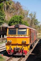 de dieselelektrische locomotief staat geparkeerd bij een klein treinstation. foto