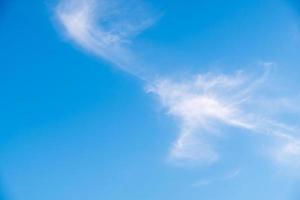 pluizige wolk drijft op de heldere blauwe lucht. foto