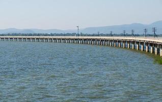 gebogen betonnen brug van de spoorlijn langs het stuwmeer met de verkeerslichtpaal. foto