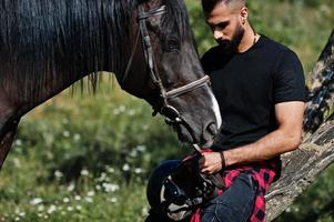 Arabische lange baard man slijtage in het zwart met Arabisch paard. foto