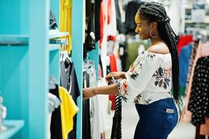 afrikaanse vrouw die kleding kiest in de winkel. shop dag.
