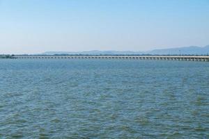de lange betonnen brug van de spoorlijn over het grote stuwmeer. foto