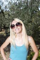 blond meisje met zonnebril glimlacht foto