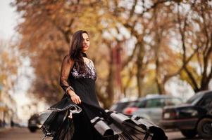 vrij indisch meisje in zwarte saree-jurk poseerde buiten in de herfststraat. foto