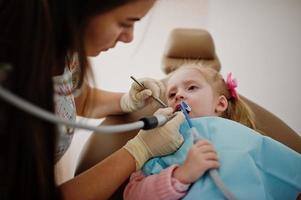 babymeisje bij tandartsstoel. kinderen tandheelkundige. foto