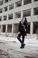 brunette stijlvolle casual meisje in sjaal tegen verlaten fabrieksplaats. foto