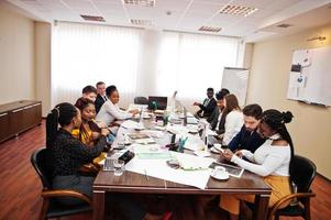 multiraciale business team adressering vergadering rond boardroom tafel. foto