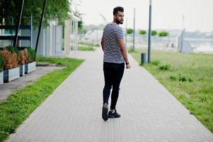 knappe lange Arabische baard man model op gestript shirt buiten geposeerd. modieuze Arabische man. foto