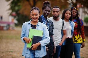 rij van groep vijf Afrikaanse studenten die samen tijd doorbrengen op de campus op het universiteitsterrein. zwarte afro-vrienden studeren. onderwijs thema. foto