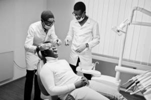 Afro-Amerikaanse man patiënt in tandartsstoel. tandartspraktijk en dokterspraktijkconcept. professionele tandarts die zijn patiënt helpt bij medische tandheelkunde. foto