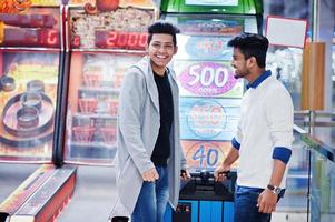 twee jonge aziatische jongens spelen in het rad van fortuin om een grote loterijprijs te winnen. foto
