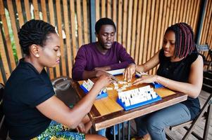 groep van drie Afro-Amerikaanse vrienden spelen tafelspellen. foto