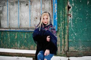 blond meisje met hand geborduurde sjaal gesteld op winterdag. dames zakdoek. foto