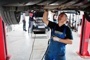 auto reparatie en onderhoud thema. monteur in uniform werken in autoservice. foto