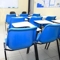 stoelen en tafels in een klaslokaal foto