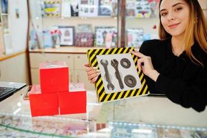 portret van jonge blanke vrouwelijke vrouw verkoper bezit set van mechanische tools gemaakt door chocolade. klein bedrijf van snoep souvenirs winkel. cadeau voor de echte man. foto