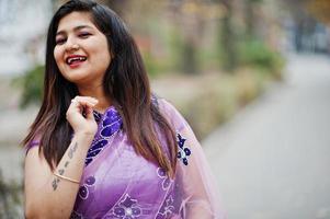 close-up portret van Indiase hindoe meisje op traditionele violet saree gesteld op straat. foto