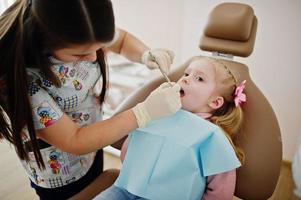 babymeisje bij tandartsstoel. kinderen tandheelkundige. foto
