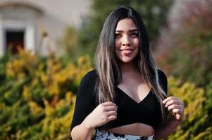 mooie latino model meisje uit ecuador dragen op zwarte tops en rok geposeerd op straat. foto