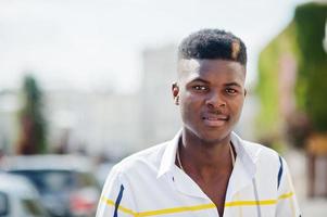 portret van knappe stijlvolle Afro-Amerikaanse model man in rode broek en wit overhemd gesteld op straat. foto