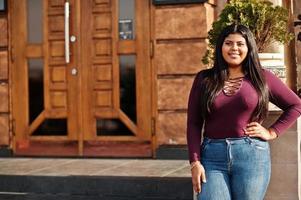 mooie latino xxl model meisje uit ecuador slijtage op violet blouse gesteld op straat. foto