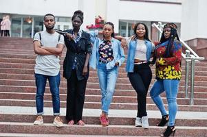 groep van vijf afrikaanse studenten die samen tijd doorbrengen op de campus op de universiteitswerf. zwarte afro-vrienden studeren. onderwijs thema. foto