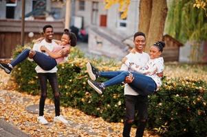 vier afrikaanse vrienden lopen door de straten van een oude stad op een zonnige herfstdag. foto