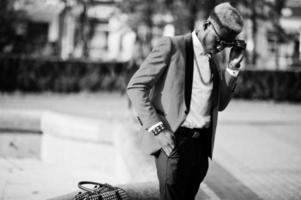 mode Afro-Amerikaanse man model op rood pak, met hoogtepunten haar en handtas gesteld op straat. foto