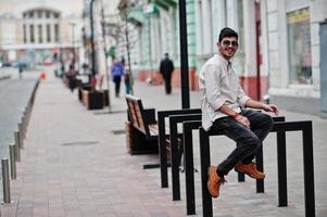 stijlvolle Indiase model man in casual kleding en zonnebril poseerde buiten op straat van india. foto