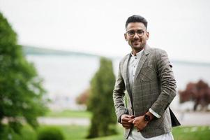 stijlvolle pakistaanse man dragen in brillen en jas. foto