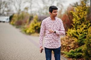 Indiase man student aan shirt poseerde buiten. foto
