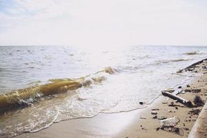 menselijk afval weggooien rommel waterfles op het zand, laat de zee rotten, wat leidt tot bederf van de zee. strandafval milieuschade veroorzaakt opwarming van de aarde. zachte focus. foto