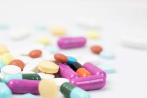 close-up macro pil morsen verstoord. kleurrijke pillencapsule op oppervlaktetabletten op een witte achtergrond. drug medische gezondheidszorg concept. foto