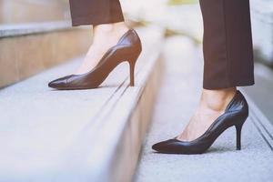 moderne zakenvrouw werkende vrouw close-up benen lopen de trap op in de moderne stad in de spits om haast te werken op kantoor. tijdens de eerste werkdag. laat ruimte voor het schrijven van beschrijvende tekst foto