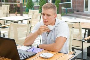 jonge man zit in café foto