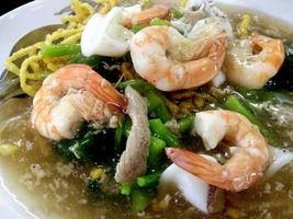 close-up gebakken noedels en knapperige rijst met zeevruchten in schotel, bovenaanzicht Aziatische keuken foto