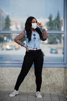 Afro-Amerikaanse jonge vrijwilligersvrouw die in openlucht gezichtsmasker draagt. coronavirus quarantaine en wereldwijde pandemie. foto