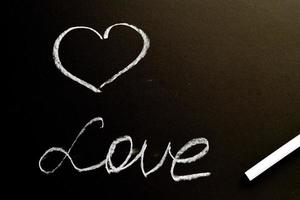 een krijtbord met het woord liefde en een hart. grunge achtergrond textuur foto