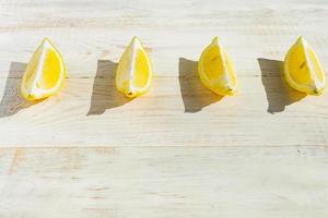 close-up van kwart citroenen op houten tafel. harde schaduwen op een zonnige dag foto