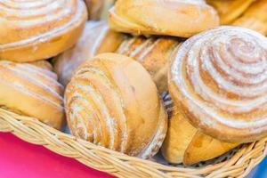 close-up van versgebakken kaneelbroodjes met poedersuiker in mand foto