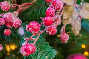 Kerstmis en Nieuwjaar vakantie achtergrond. kerstboom versierd met rode frosted bessen en kegels. viering concept foto