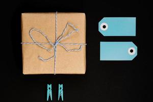 handgemaakte geschenkdozen verpakt in ambachtelijk papier met blauw papieren kaartlabel, touw en houten wasknijpers voor decoratie. foto