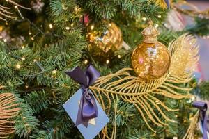 Kerstmis en Nieuwjaar vakantie achtergrond. kerstboom versierd met gouden bal en sprankelende veer. viering concept foto