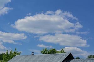 uitzicht op dak van het huis en blauwe lucht met wolken foto