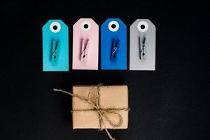 handgemaakte geschenkdozen verpakt in ambachtelijk papier met blauw en roze papieren kaartlabel, touw en houten wasknijpers voor decoratie. foto