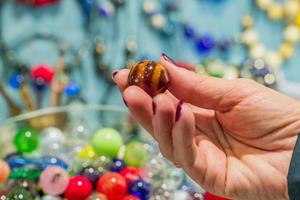 wooman met een glaskraal voor het maken van nacklesses en armbanden. diy materialen voor ambacht. foto