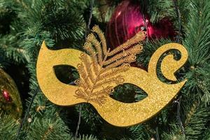 Kerstmis en Nieuwjaar vakantie achtergrond. kerstboom versierd met gouden masker, ballen en slingers foto