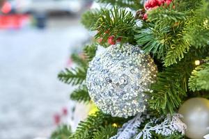 close-up van de kerstboom versierd met silferr sprankelende ballen en guirlande met lampjes aan. feestelijke achtergrond met kopieerruimte voor uw projecten foto